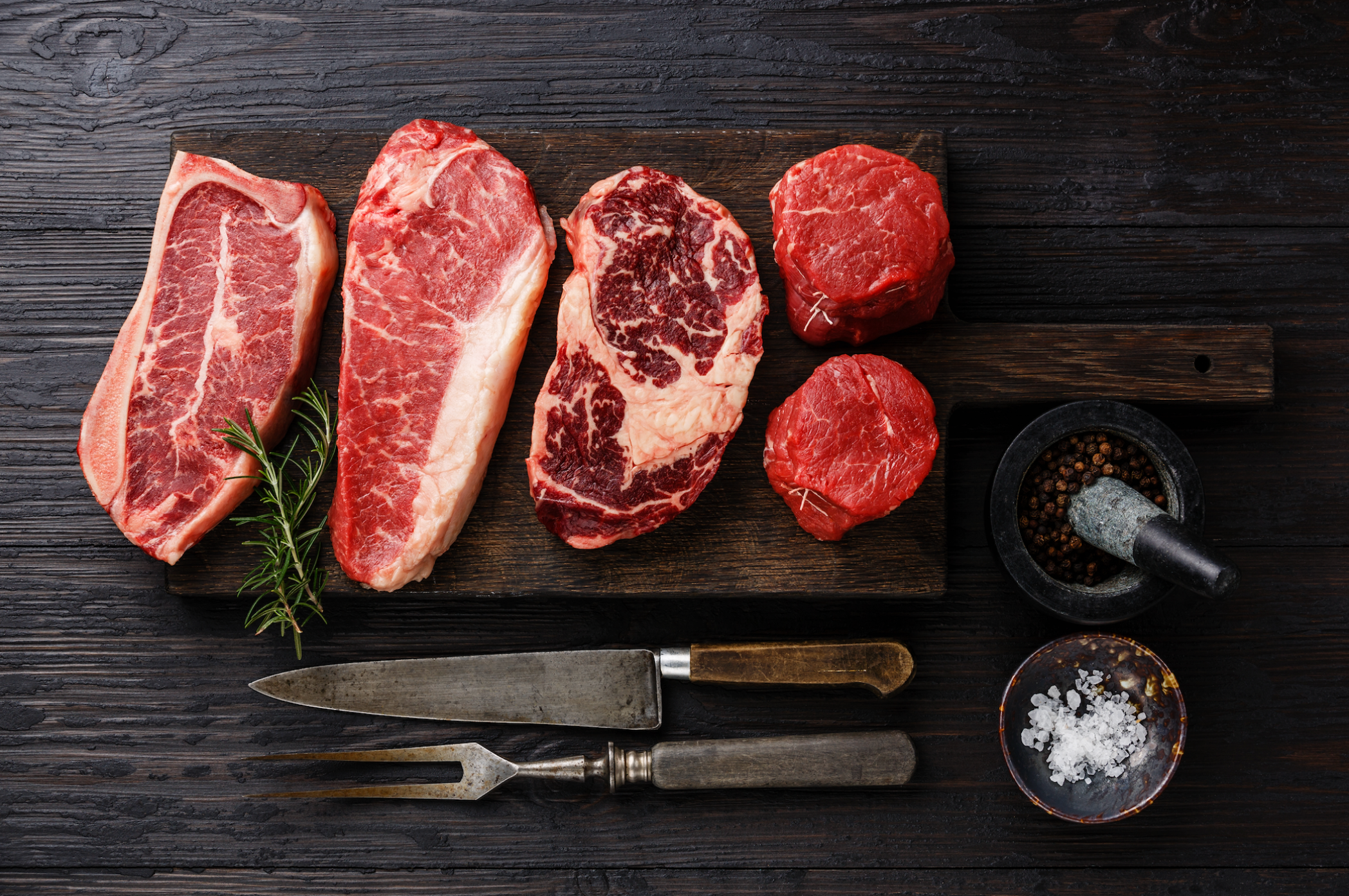 Premium Photo  Raw pieces of beef on a cutting board with a knife